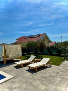 a patio with two lounge chairs and a pool at Villa C'est la vie in Kaštela