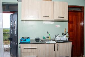 a kitchen with wooden cabinets and a sink and a refrigerator at Patrach Homes in Wote