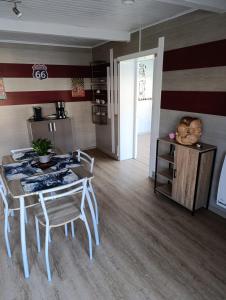 a kitchen with a table and chairs in a room at La maisonnette des Fontilles in Mauriac