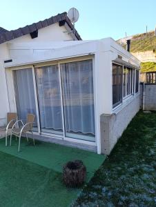 a house with sliding glass doors and a yard at La maisonnette des Fontilles in Mauriac