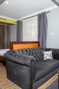 a black couch in a living room with a window at Patrach Homes in Wote +4 photos