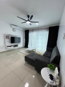 a living room with a couch and a ceiling fan at SDC Suite Home 4 in Lahad Datu