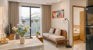 a living room with a couch and a chair and a window at SHome, căn hộ 55m2,2 phòng ngủ, Oceanpark 1 in Gia Lâm Pho