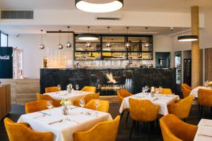 a restaurant with tables and chairs and a bar at BL Garden Panzió in Balatonlelle