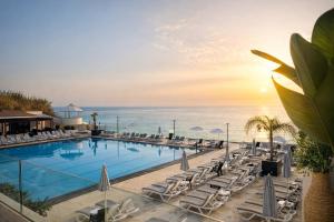 a pool with chairs and the ocean in the background at Gondola Marine Resort in Ḩālāt