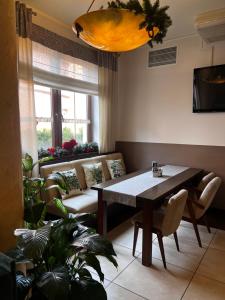 a living room with a table and a couch at Matrioszka Pokoje Hotelowe in Gołdap