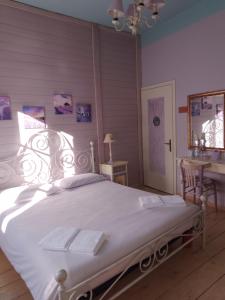 a bedroom with a white bed with a desk and a table sidx sidx at B&B Rossociliegia in Castelbianco