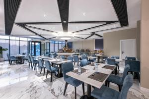ein Esszimmer mit Tischen, Stühlen und Fenstern in der Unterkunft Karim Hotel in Dammam