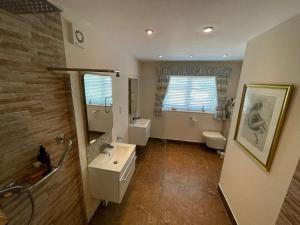 a bathroom with a sink and a toilet at The Cherries in Penrhyn Bay +32 photos