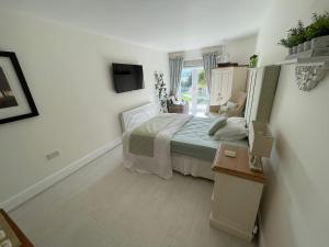 a small bedroom with a bed and a window at The Cherries in Penrhyn Bay