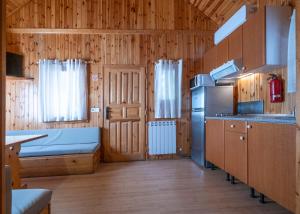 a kitchen with a refrigerator and a bed in a room at La Borda del Pubill Resort in Ribera de Cardós