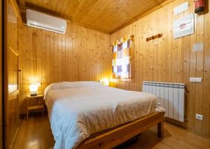 a bedroom with a bed in a wooden wall at La Borda del Pubill Resort in Ribera de Cardós +105 photos