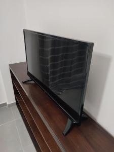 a flat screen tv sitting on top of a wooden table at By the wave luxurious studios in Piraeus