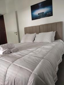 a large white bed with two pillows on it at By the wave luxurious studios in Piraeus
