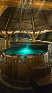 a hot tub in a wooden building with a roof at Osada Kuboski Dom z Bali Leśny Zakątek in Kamesznica