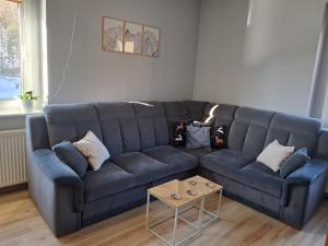 a blue couch in a living room with a table at Sowie Pokoje in Jugów