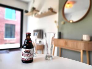 a bottle of beer sitting on a table with two glasses at Waterloo Downtown Park in Waterloo