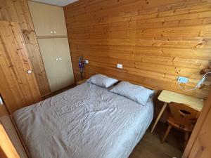 a bedroom with a bed and a wooden wall at Il Nido - Family Apartment con Spa & Mini Club a Cavalese in Carano +14 photos