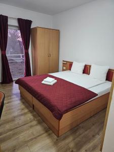 ein Schlafzimmer mit einem großen Bett und einer roten Decke in der Unterkunft ViiLaEne in Deta + 16 Fotos