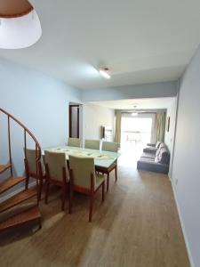 a living room with a table and chairs and a couch at Duplex 11 Pessoas-Churrasqueira-Próximo ao Mar in Itapema