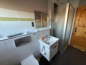 a white bathroom with a sink and a mirror at Strandgut- die Große in Dranske +21 photos
