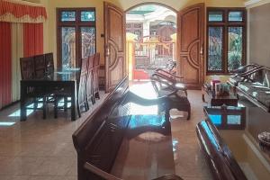 a living room with a dining table and chairs at Bromo Indah Lestari Homestay Mitra RedDoorz in Pasuruan