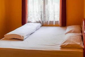a bed sitting in a room with a window at Bromo Indah Lestari Homestay Mitra RedDoorz in Pasuruan