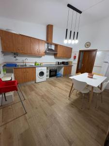 a kitchen with a white table and chairs and a table and a kitchen with at Casa da Avó Virgínia in Elvas