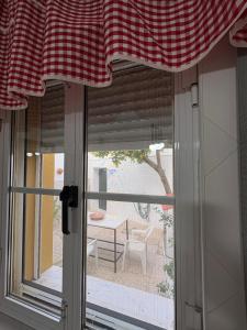 a window with a red and white checkered curtain at Casa da Avó Virgínia in Elvas +13 photos