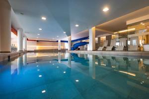 a large swimming pool with a slide in a building at Il Nido - Family Apartment con Spa & Mini Club a Cavalese in Carano