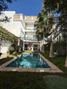 a swimming pool in front of a house at Oasis TIFNIT Villa with Pool View No vis A vis in Draïd