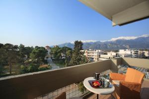 balcón con mesa, sillas y montañas en Dioscouri Hotel en Sparti