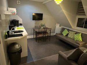 a living room with a couch and a table at Rivendell Holiday Studios & Suite in Swanage