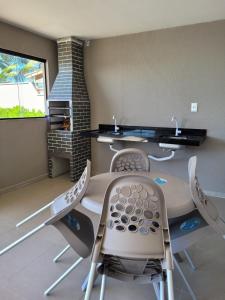 a room with chairs and a table and a window at Pontal Flat 103 in Coruripe