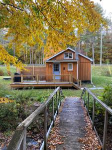 a house with a porch and a bridge leading to it at Cozy stream-side cabin in Lanesborough