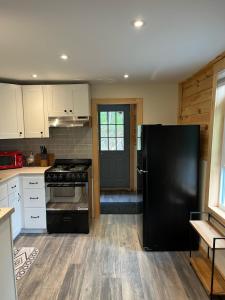 a kitchen with black appliances and a black refrigerator at Cozy stream-side cabin in Lanesborough +17 photos