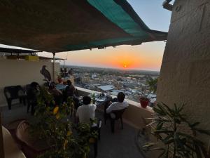a group of people sitting at a table watching the sunset at Hotel Mirage in Jaisalmer