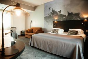 a hotel room with a bed and a couch at Logis Hôtel Victor Hugo & Spa in Besançon +39 photos