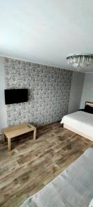 a bedroom with a bed and a table and a tv at Рахмет in Petropavlovsk