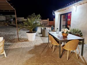 a dining table and chairs in a patio at Le cottage Bleu du Sud in Saint-Étienne-les-Orgues