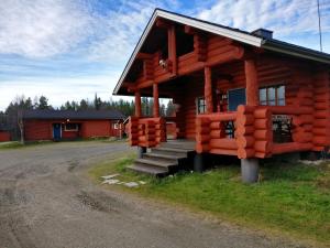 a log cabin house with a staircase to the front at Peurasuvanto Mökit & Camping in Peurasuvanto