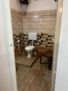 a bathroom with a toilet and a wooden wall at THEE Confort rooms in Pondicherry