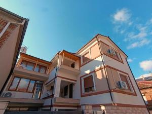 a large white house with a blue sky in the background at Zafir Apartment in Korçë