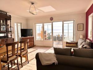 a living room with a couch and a television at Casa Eugenia in Sesimbra