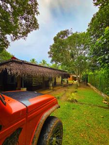 a red truck parked in front of a house at Elephant paradise Safari resort in Udawalawe