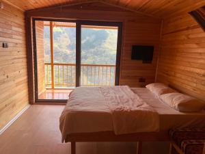 a bedroom with a bed and a large window at Hamsiköy Seyirtepe Butik Otel in Hamsikoy
