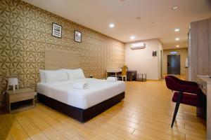 a bedroom with a large white bed and a desk at Bangi Perdana Hotel in Bangi