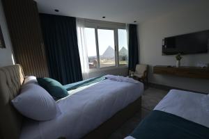 a hotel room with two beds and a window at Delta Pyramids Hotel in Giza