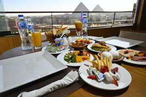 a table topped with plates of food and drinks at Delta Pyramids Hotel in Giza