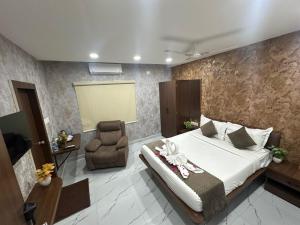 a bedroom with a large bed and a chair at Hotel Apex Inn Hyderabad Airport in Hyderabad